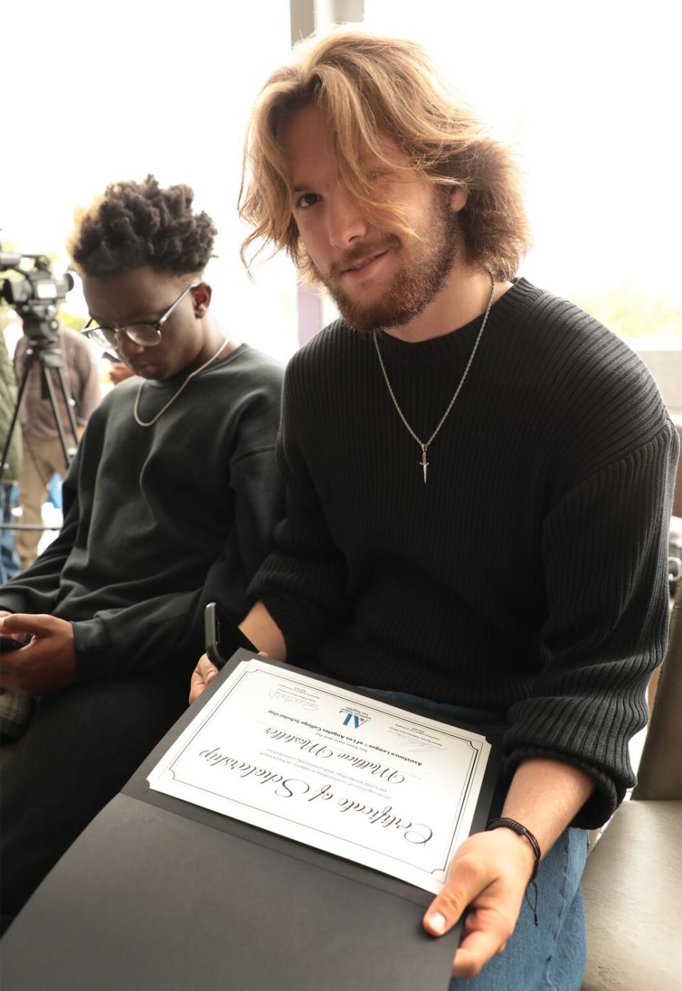 Graduating senior Matthew Mosteller holds a scholarship certificate.