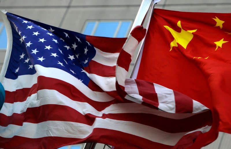 National flags of U.S. and China wave in front of an international hotel in Beijing