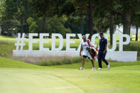 Adam Scott, of Australia, right, walks along the 13th fairway with his caddie during the first round of the St. Jude Championship golf tournament Thursday, Aug. 11, 2022, in Memphis, Tenn. (AP Photo/Mark Humphrey)