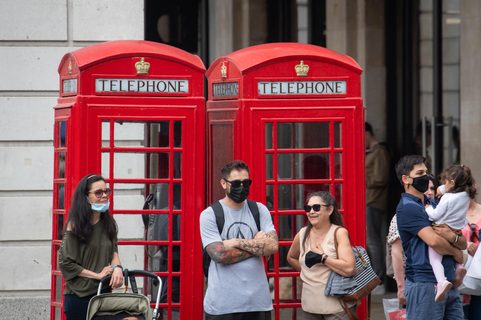 People wearing face masks watch a street entertainer in Covent Garden, London. Rumours were abound in the Sunday newspapers that Prime Minister Boris Johnson, who is due to update the nation this week on plans for unlocking, is due to scrap social distancing and mask-wearing requirements on so-called 