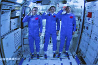 In this photo released by Xinhua News Agency, Chinese astronauts salute after successfully entering the Tianhe space station module as they are displayed on a big screen at the Beijing Aerospace Control Center in Beijing, on Thursday, June 17, 2021. China has launched the first three-man crew to its new space station in its the ambitious programs first crewed mission in five years (Jin Liwang/Xinhua via AP)