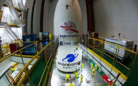 The fairing of the Ariane 5 launcher is lowered over the BepiColombo spacecraft stack.  - Credit: Manuel Pedoussaut