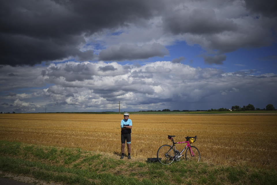 A lone cyclist waits roadside for the peloton to pass during the sixth stage of the Tour de France cycling race over 163.5 kilometers (101.6 miles) with start in Macon and finish in Dijon, France, Thursday, July 4, 2024. (AP Photo/Daniel Cole)
