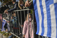 People watch the military parade at the northern port city of Thessaloniki, Greece, Thursday, Oct. 28, 2021 .The parade is held to celebrate Greece's refusal to align itself with a belligerent fascist Italy in 1940 and instead fight a much stronger opponent, a decision which dragged it into World War II and eventually led to a brutal occupation by Nazi Germany. (AP Photo/Giannis Papanikos)