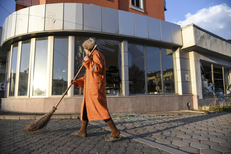 A municipal worker sweeps a street after shelling during a military conflict in self-proclaimed Republic of Nagorno-Karabakh, Stepanakert, Azerbaijan, Saturday, Oct. 3, 2020. The fighting is the biggest escalation in years in the decades-long dispute over the region, which lies within Azerbaijan but is controlled by local ethnic Armenian forces backed by Armenia. (David Ghahramanyan/NKR InfoCenter PAN Photo via AP)