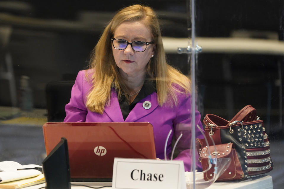 FILE- Virginia State Sen. Amanda Chase, R-Chesterfield, front, works on the laptop prior to the Senate special session at the remote location in Richmond, Va., Feb. 11, 2021. (AP Photo/Steve Helber, File)