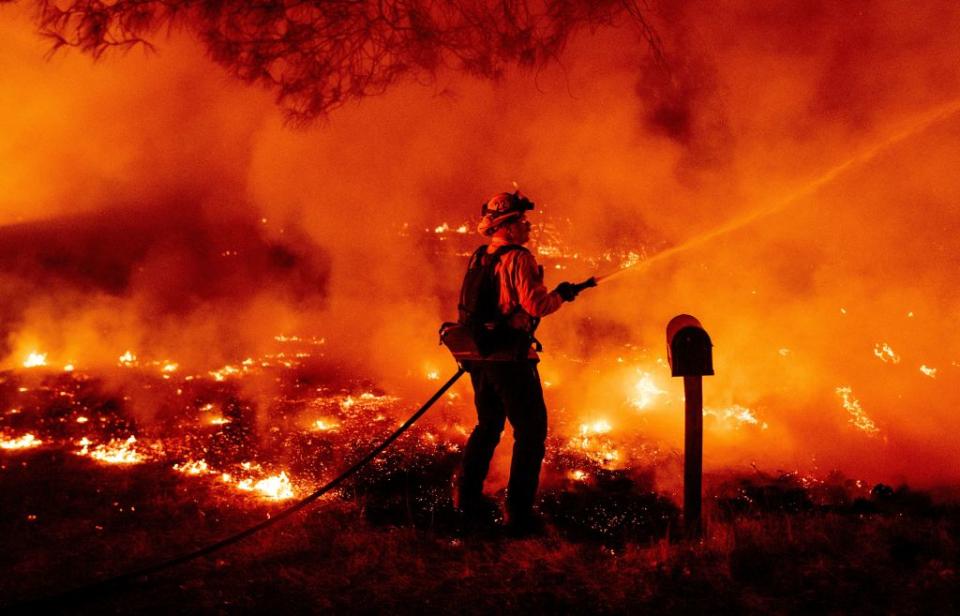 A Butte county firefighter douses flames at the Bear fire in Oroville, California on September 9, 2020AFP via Getty Images