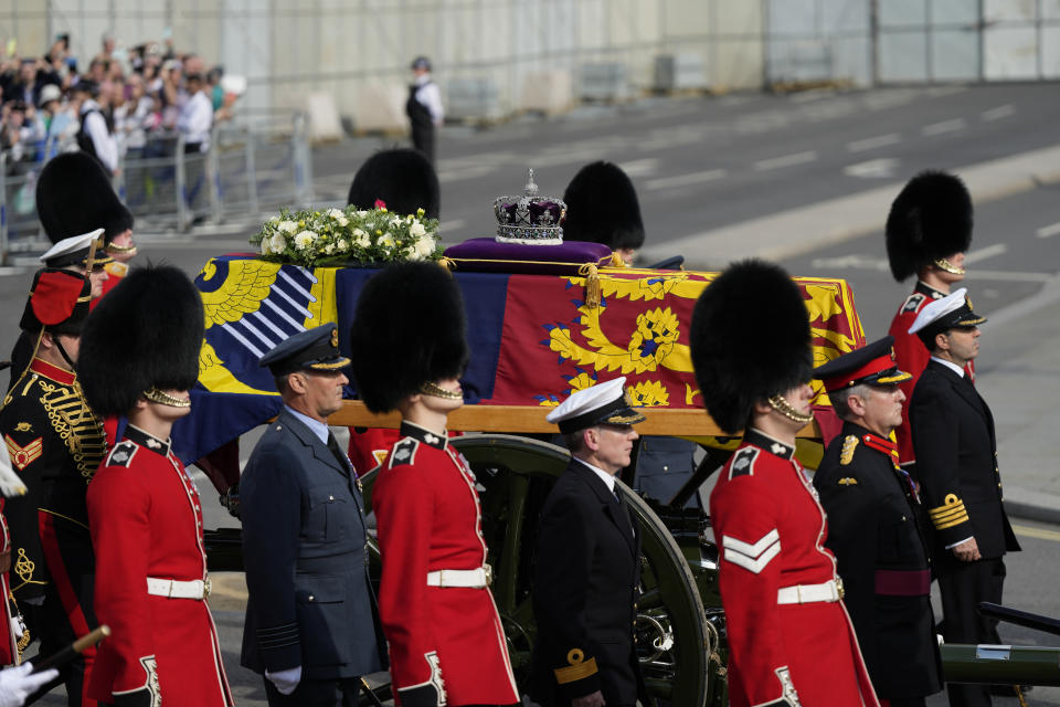 The coffin of Queen Elizabeth II, draped in the Royal Standard, is carried on a horse-drawn gun carriage of the King's Troop Royal Horse Artillery, during the ceremonial procession from Buckingham Palace to Westminster Hall, London, where it will lie in state ahead of her funeral on Monday. Picture date: Wednesday September 14, 2022.