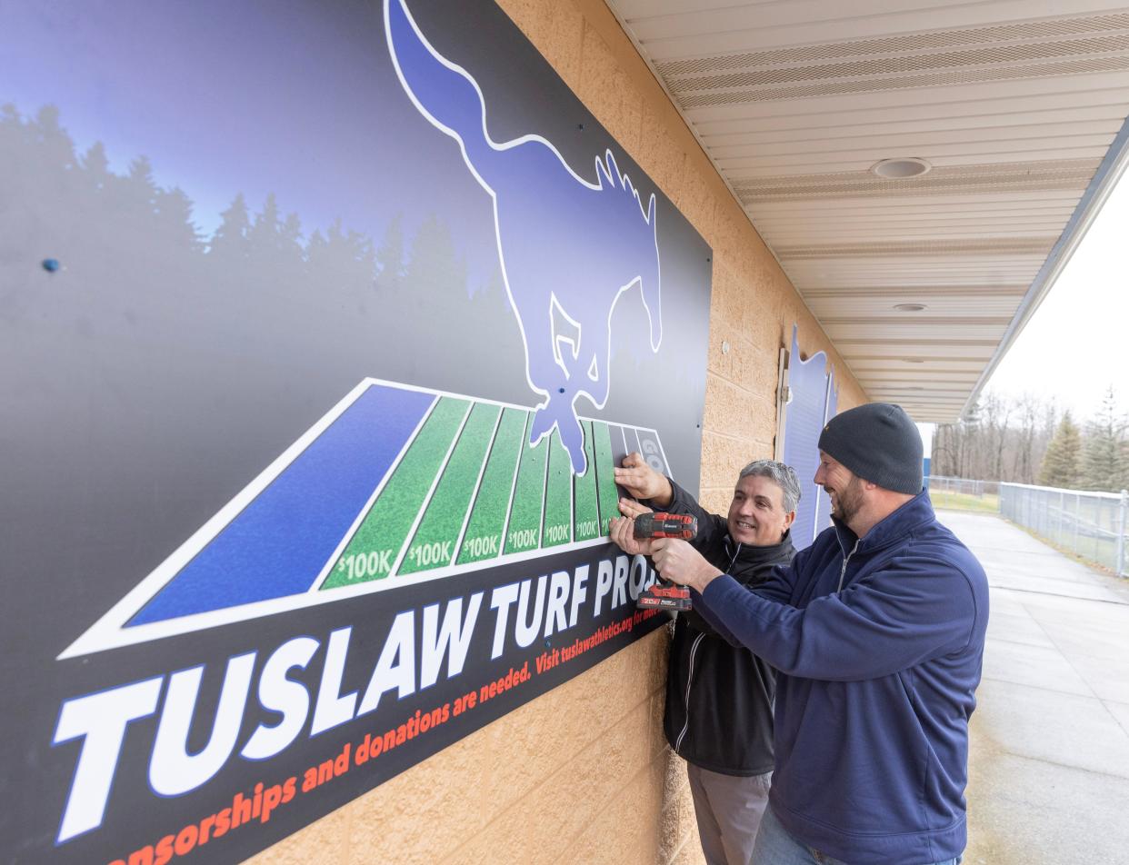 Jesse Gleespen, right, and Tuslaw athletic director Chris Lapish update the Tuslaw turf project progress sign. A volunteer committee headed up by Gleespen has collected about $775,000 of their $950,000 goal to bring synthetic turf to William E. Kurtz field.