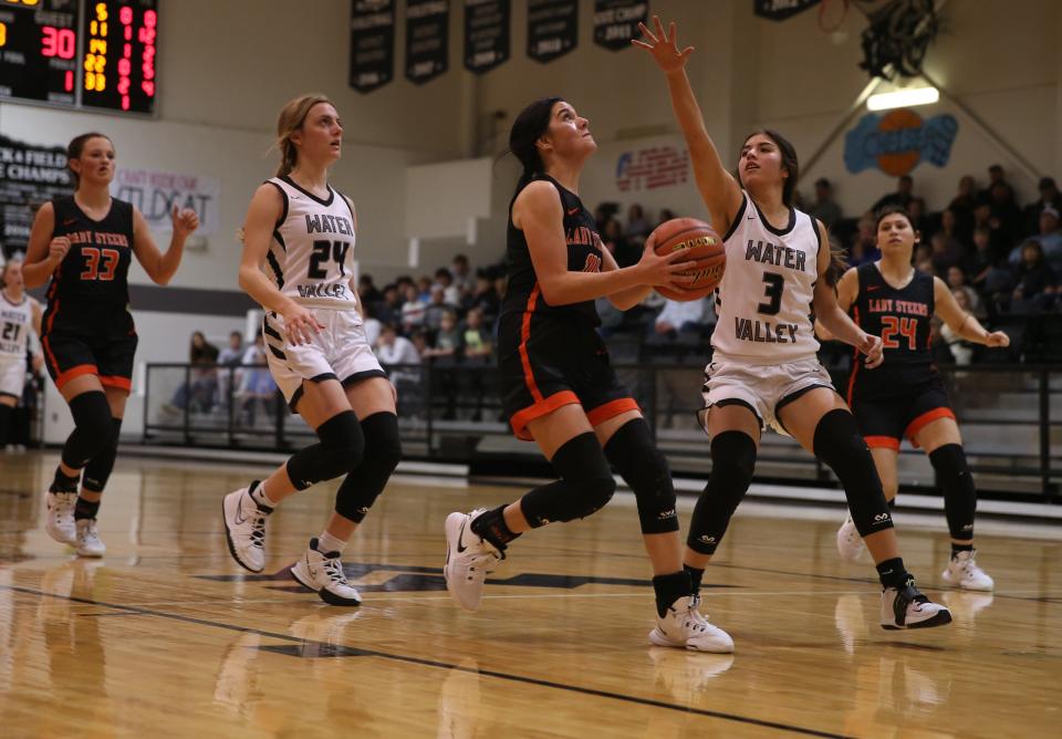 Robert Lee High School's Mia Galvan drives the lane for a layup while Water Valley's Jayden Gomez (3) in a District 11-1A girls basketball game Friday, Jan. 7, 2022 at Water Valley.