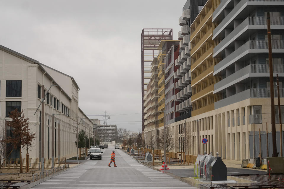 A worker walks in a street of the Olympic village, in Saint-Denis, north of Paris Wednesday, Feb. 28, 2024. When French President Emmanuel Macron inaugurates the Olympic village on Thursday, Feb. 29, he will see a run-down area transformed into an international hub for the Paris Games. (AP Photo/Thibault Camus)