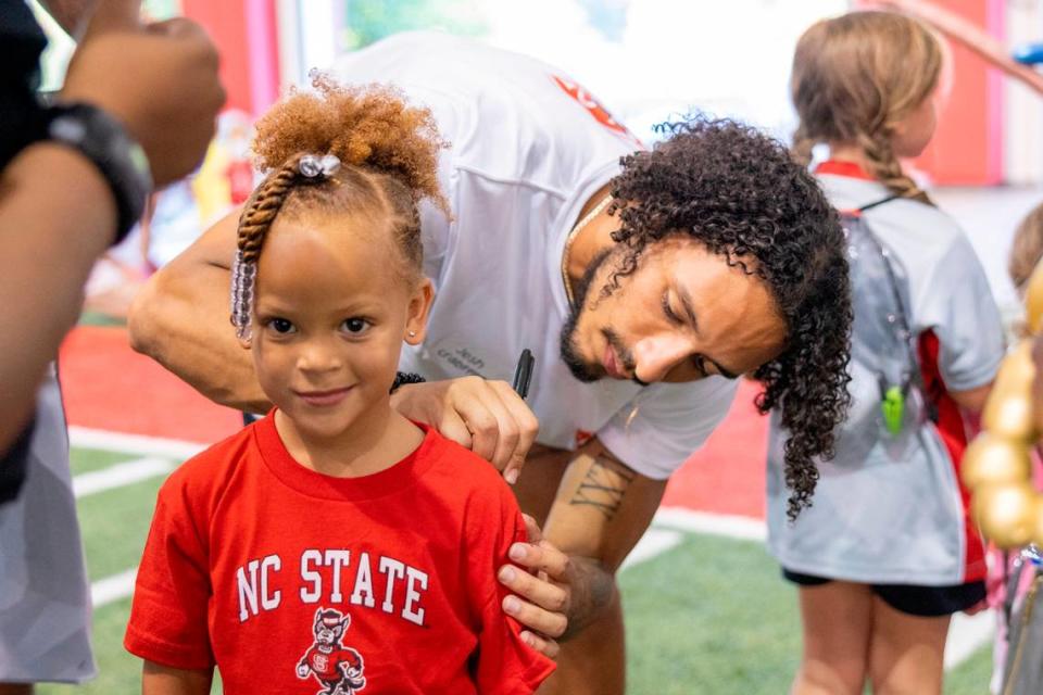 N.C. State’s Josh Crabtree autographs 5-year-old Kensli Ray’s shirt during a ‘Meet the Pack’ event with football players and fans at the Close-King Indoor Practice Facility Saturday, Aug. 16, 2023.