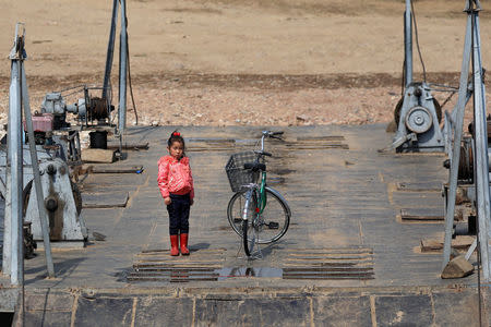 A girl stands on a ferry on the North Korean side of the Yalu River, just north of Sinuiju, North Korea, April 2, 2017. REUTERS/Damir Sagolj