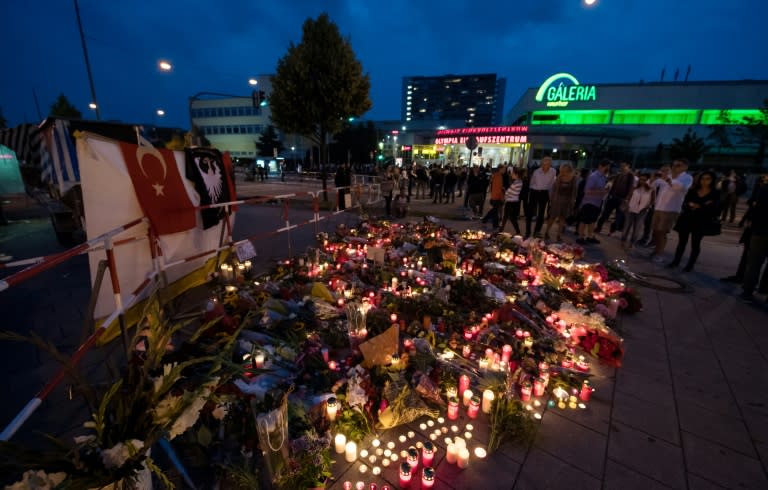 Candles and flowers lie in front of the Olympia-Einkaufszentrum shopping centre in Munich