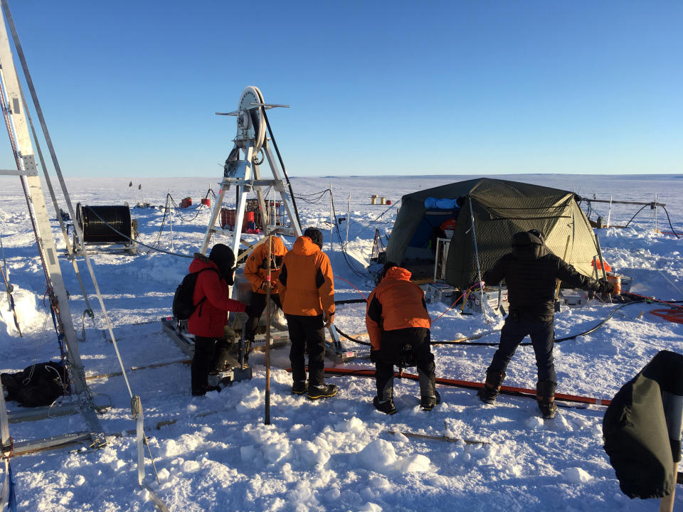 Miembros del equipo de la Prospección Antártica Británica perforan un agujero en la plataforma de hielo del Thwaites para colocar instrumentos debajo del hielo. (Icefin/ITGC/Schmidt vía The New York Times).