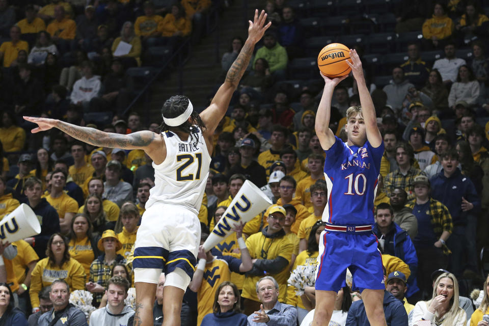 Kansas guard Johnny Furphy (10) is defended by West Virginia guard RaeQuan Battle (21) during the first half of an NCAA college basketball game on Saturday, Jan. 20, 2024, in Morgantown, W.Va. (AP Photo/Kathleen Batten)