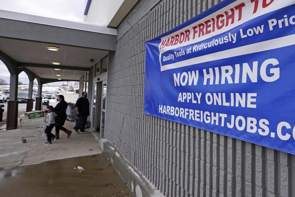 A "Now Hiring" sign hangs on the front wall of a Harbor Freight Tools store, Thursday, Dec. 10, 2020, in Manchester, N.H. The number of Americans seeking unemployment benefits fell by 19,000 to a still-high 787,000, evidence that the job market remains under stress as a resurgent coronavirus continues to batter the economy. (AP Photo/Charles Krupa)