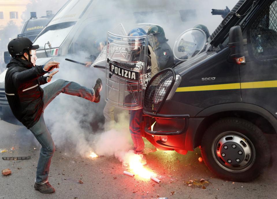 A protester clashes with a Guardia di Finanza policeman in front of the Ministry of Finance building in downtown Rome