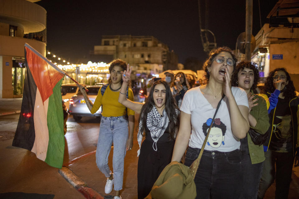 Arab women, one holding a Palestinian flag, shout slogans against Jewish nationalist religious groups that are buying up property in the Arab neighborhood of Jaffa in Tel Aviv, Israel, Saturday, April 24, 2021. Historic Jaffa's rapid gentrification in recent years is coming at the expense of its mostly Arab lower class. With housing prices out of reach, discontent over the city’s rapid transformation into a bastion for Israel’s ultra-wealthy is reaching a boiling point. (AP Photo/Ariel Schalit)