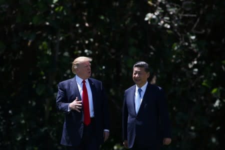 U.S. President Donald Trump and China's President Xi Jinping chat as they walk along the front patio of the Mar-a-Lago estate after a bilateral meeting in Palm Beach