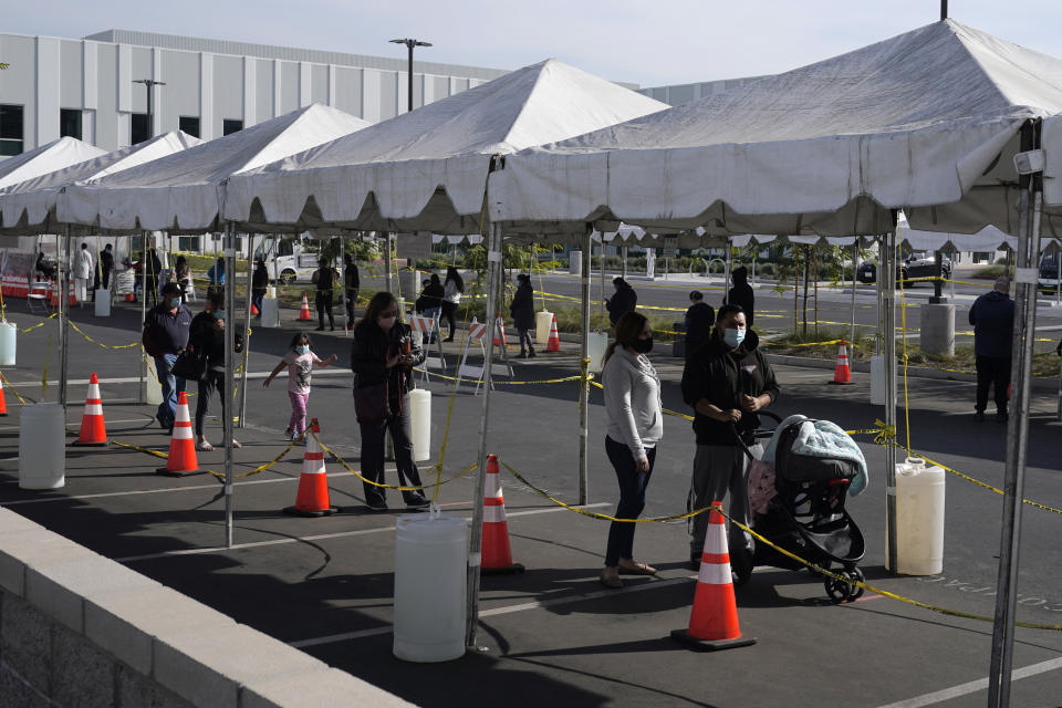 FILE - In this Jan. 7, 2021, file photo, people line up at a COVID-19 walk-up testing site on the Martin Luther King Jr. Medical Campus in Los Angeles. Coronavirus deaths and cases per day in the U.S. dropped markedly over the past couple of weeks but are still running at alarmingly high levels, and the effort to snuff out COVID-19 is becoming an ever more urgent race between the vaccine and the mutating virus. (AP Photo/Marcio Jose Sanchez, File)