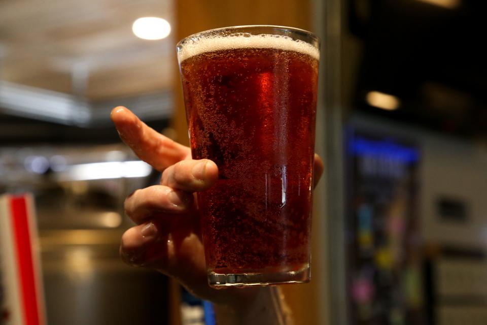 Kyle Pryor, the brewmaster at Railroad Seafood Station & Brewing Co., holds a pint of Cerveza de la Flor Tuesday, July 26, 2022. The beer is one of the most popular drinks requested at the brewery.