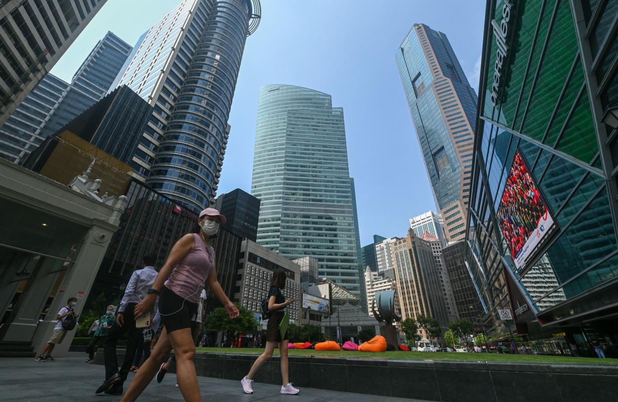 Pedestrians walk below the highrise office buildings at the financial business district of Raffles Place in Singapore on August 8, 2022. (Photo by Roslan RAHMAN / AFP) (Photo by ROSLAN RAHMAN/AFP via Getty Images)