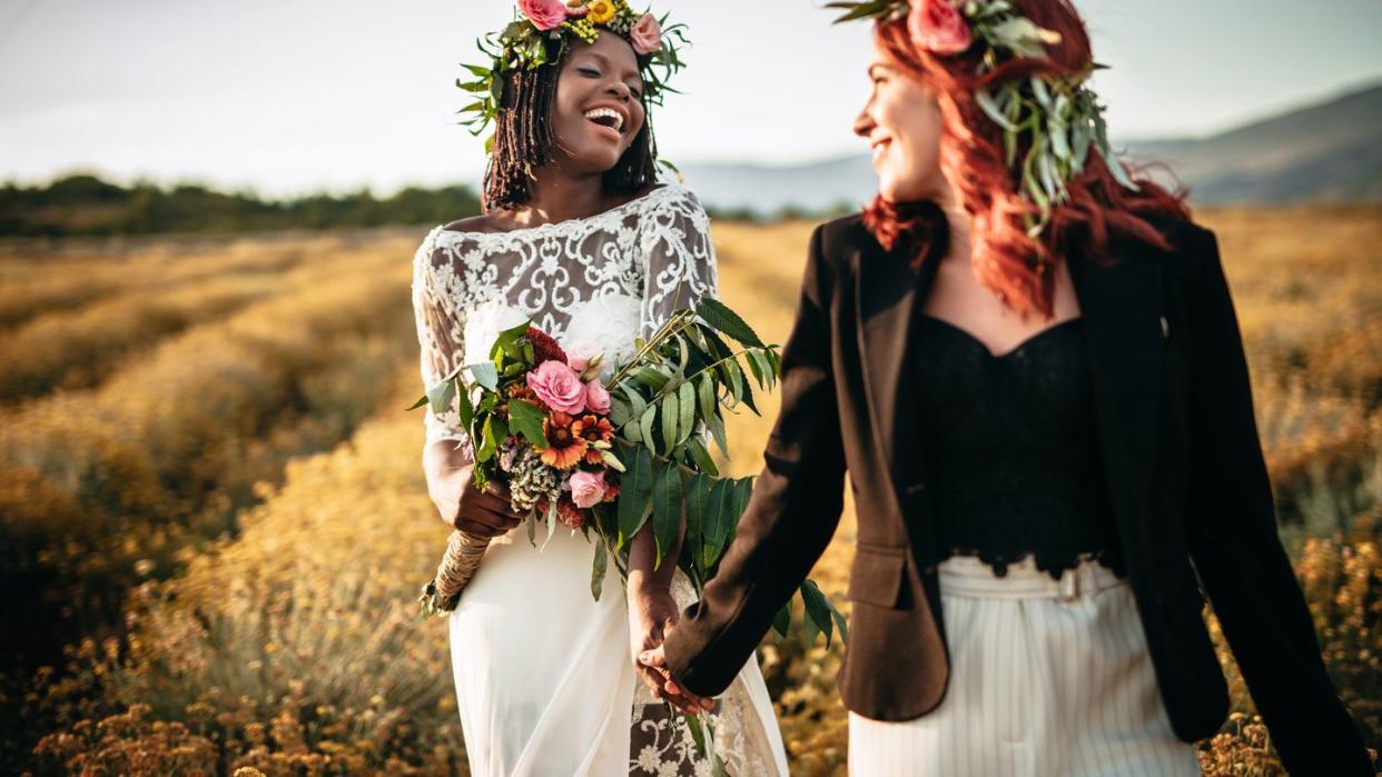 two lesbian brides walking in the flower field