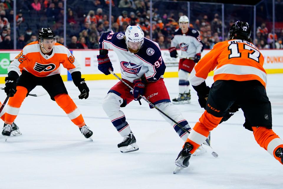 Columbus Blue Jackets' Jakub Voracek (93) tries to keep the puck away from Philadelphia Flyers' Zack MacEwen (17) and Connor Bunnaman (82) during the first period of an NHL hockey game, Thursday, Jan. 20, 2022, in Philadelphia. (AP Photo/Matt Slocum)