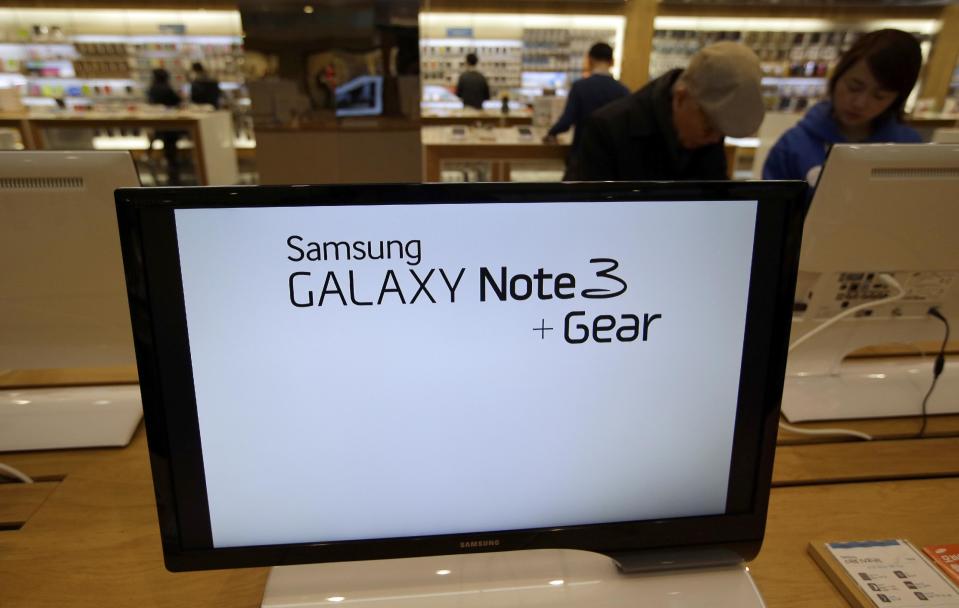 A screen displays text advertising Samsung Electronics' Galaxy Note 3 smartphones and Galaxy Gear smartwatches at a Samsung Electronics shop in Seoul, South Korea, Tuesday, Jan. 7, 2014. Samsung Electronics Co.'s fourth-quarter operating profit declined 6 percent over a year earlier, the company said Tuesday, underlining the challenges the world's largest smartphone maker faces as sales of mobile devices slow in advanced countries. (AP Photo/Lee Jin-man)