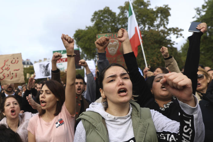 Women chant slogans during a demonstration to show support for Iranian protesters standing up to their leadership over the death of a young woman in police custody, Sunday, Oct. 2, 2022 in Paris. Thousands of Iranians have taken to the streets over the last two weeks to protest the death of Mahsa Amini, a 22-year-old woman who had been detained by Iran's morality police in the capital of Tehran for allegedly not adhering to Iran's strict Islamic dress code. (AP Photo/Aurelien Morissard)