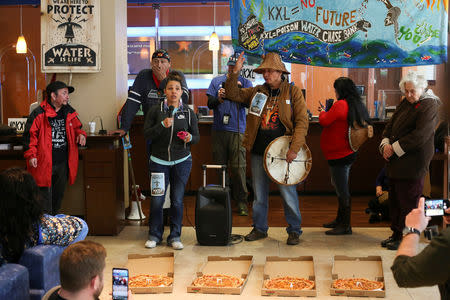 FILE PHOTO: Pizza is delivered next to Native American leaders and climate activists demonstrating inside of a Chase Bank location, in opposition to the Keystone XL pipeline, in Seattle, Washington, U.S. May 8, 2017. REUTERS/David Ryder/File Photo