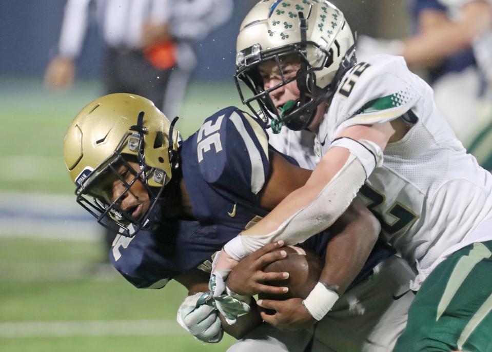 Archbishop Hoban High's Lamar Sperling is tackled by St. Vincent-St Mary High's Jason Walter after a reception during the Div. II regional semifinal football game at University of Akron's InfoCision Stadium in Akron on Friday.