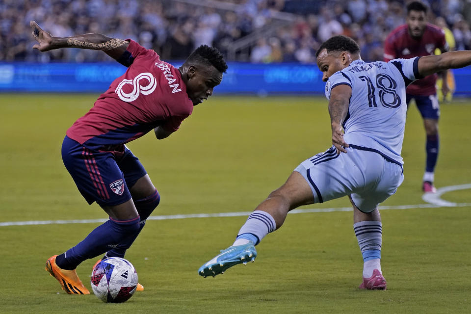 FC Dallas forward Jáder Obrian (8) tries to get past Sporting Kansas City defender Logan Ndenbe (18) during the first half of an MLS soccer match Wednesday, May 31, 2023, in Kansas City, Kan. (AP Photo/Charlie Riedel)