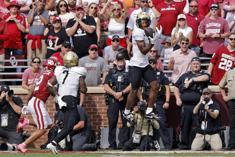 UCF wide receiver Javon Baker, right, catches a pass for a touchdown as UCF running back RJ Harvey (7) and Oklahoma defensive back Billy Bowman Jr., left, chase late in the fourth quarter of an NCAA college football game, Saturday, Oct. 21, 2023, in Norman, Okla. (AP Photo/Nate Billings)