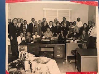 An image of the Las Cruces Sun-News staff from the 1960s, with the newspaper's owner and operator, Joseph Priestly, sitting at the desk in the middle.