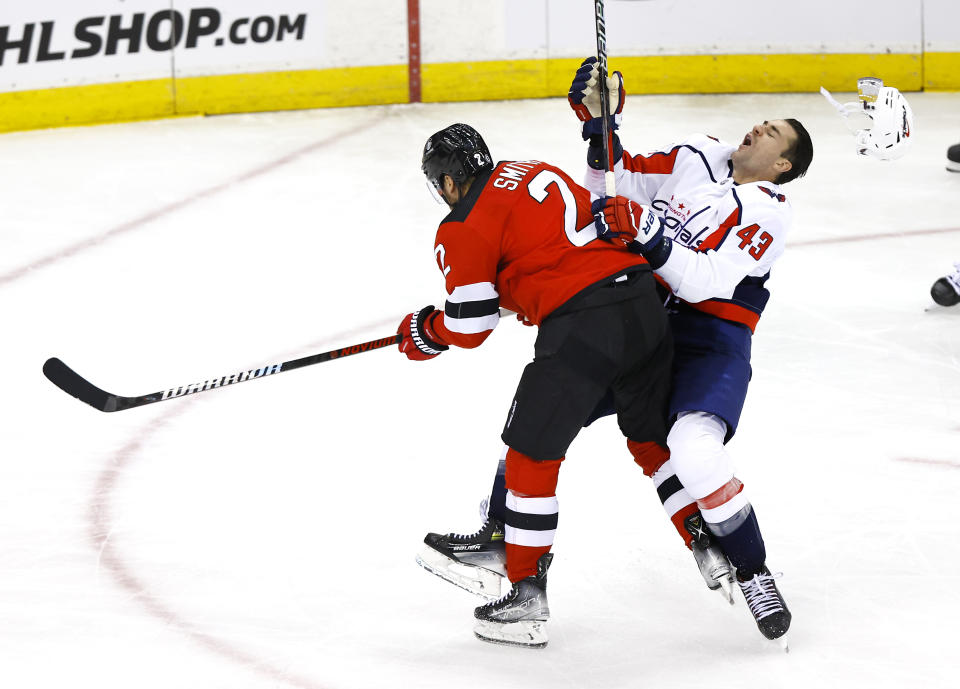 New Jersey Devils defenseman Brendan Smith (2) checks Washington Capitals right wing Tom Wilson (43) during the third period of an NHL hockey game, Friday, Nov. 10, 2023, in Newark, N.J. (AP Photo/Noah K. Murray)