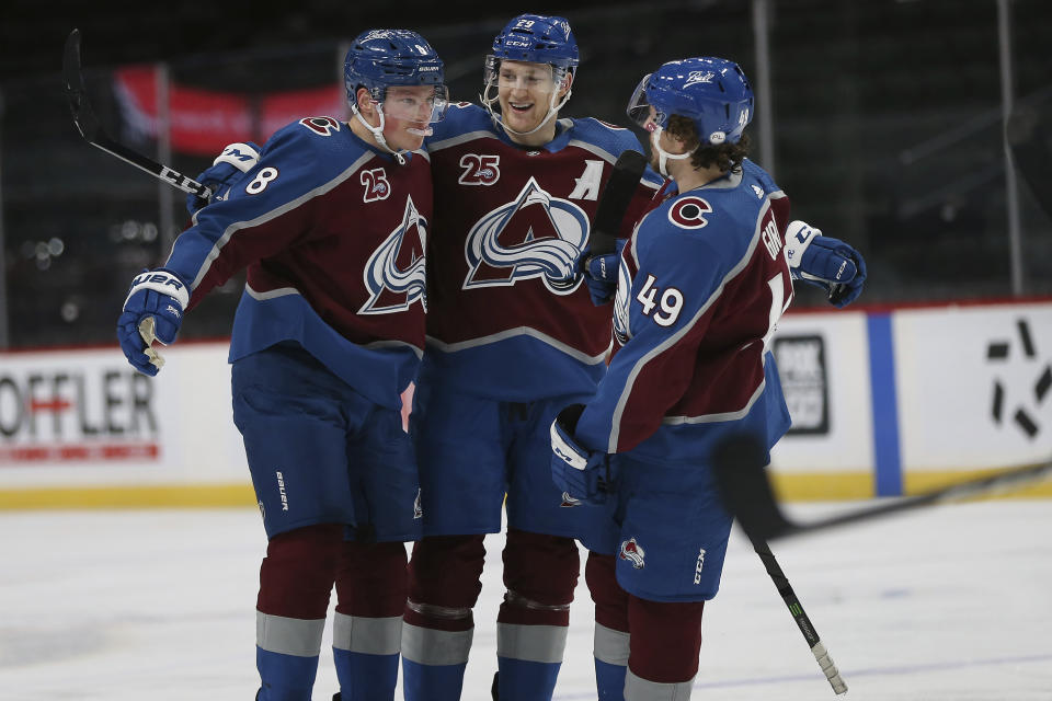 Colorado's Cale Makar (8) celebrates with teammates Nathan MacKinnon (29) and Samuel Girard (49) after scoring a goal in the second period of an NHL hockey game against the Minnesota Wild, Sunday, Jan. 31, 2021, in St. Paul, Minn. (AP Photo/Stacy Bengs)