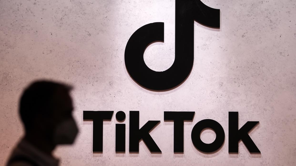 A visitor passes a TikTok logo