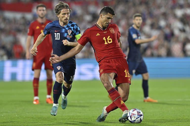 Rodri hace un pase, perseguido por Modric