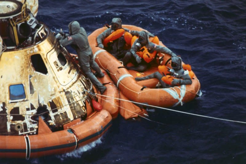 Pararescueman Lt. Clancy Hatleberg closes the Apollo 11 spacecraft hatch as astronauts Neil Armstrong, Michael Collins, and Buzz Aldrin, Jr. await a helicopter pickup from their life raft after they splashed down 900 miles southwest of Hawaii on July 24, 1969. File Photo courtesy NASA