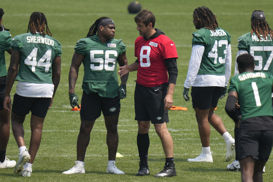 New York Jets quarterback Aaron Rodgers (8), center right, greets Quincy Williams (56), center left, at the NFL football team's training facility in Florham Park, N.J., Tuesday, June 6, 2023. (AP Photo/Seth Wenig)