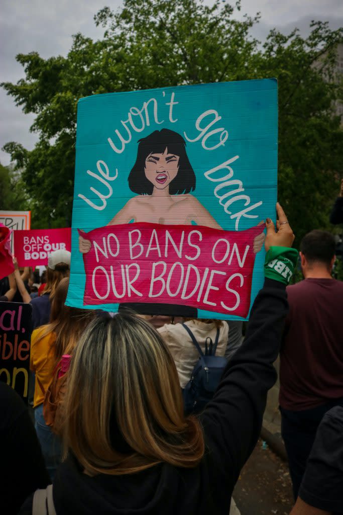 Woman holding a sign at a rally to protect abortion rights