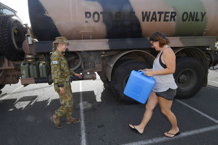 A local arrives to collect drinking water from an Australian Army tanker after Cyclone Debbie caused damage to local drinking water supplies in the town of Airlie Beach, located south of the northern Queensland town of Townsville in Australia, March 31, 2017. AAP/Dan Peled/via REUTERS