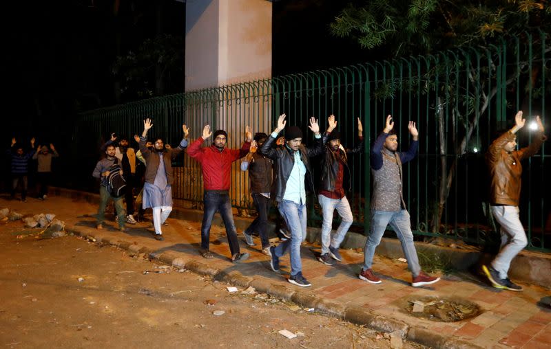 FILE PHOTO: Students raising their hands leave the Jamia Milia University following a protest against a new citizenship law, in New Delhi