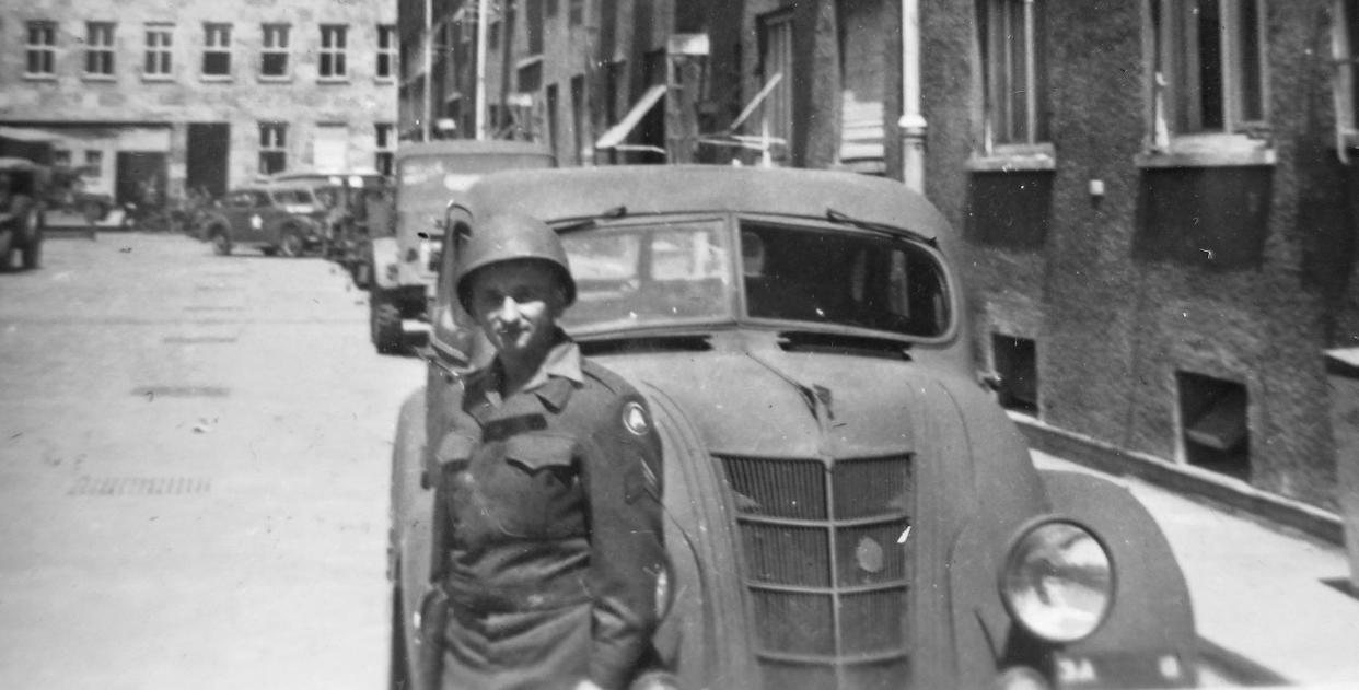 Benjamin Ferencz in uniform standing next to a car in Munich in 1945. 
