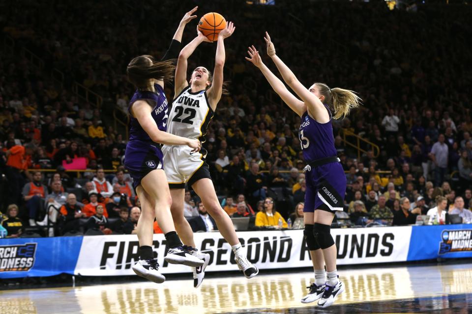 Holy Cross defenders Kaitlyn Flanagan, left, and Bronagh Power-Cassidy, right, contest a shot by Iowa's Caitlin Clark during Saturday's NCAA Tournament first-round game.