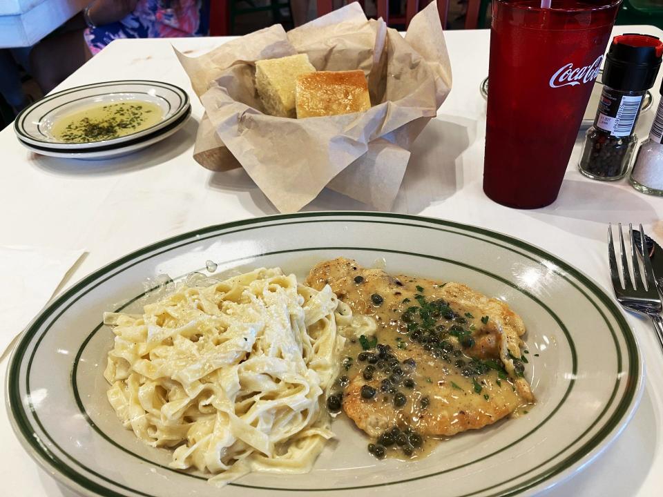 Chicken piccata is served with Fettuccini Alfredo and complimentary Focaccia bread with olive oil and herbs for dipping at Mandola's Italian Kitchen.