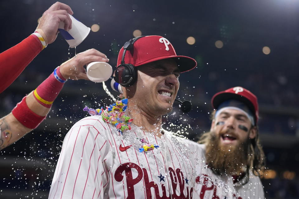 Philadelphia Phillies' J.T. Realmuto, center, is doused by Brandon Marsh, right, and Bryson Stott after a baseball game against the Texas Rangers, Wednesday, May 22, 2024, in Philadelphia. (AP Photo/Matt Slocum)