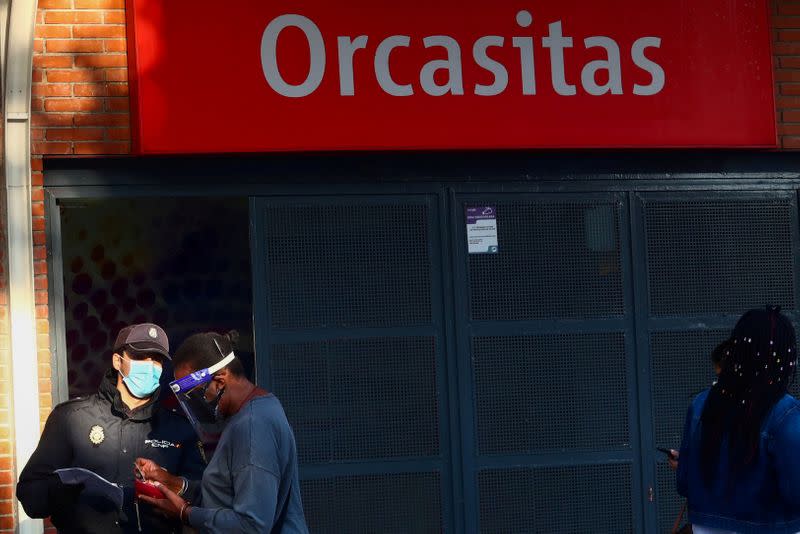 FILE PHOTO: A National Police officer inspects documents of a woman in Madrid